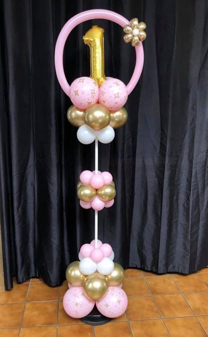 A pink and gold balloon display for a first birthday.