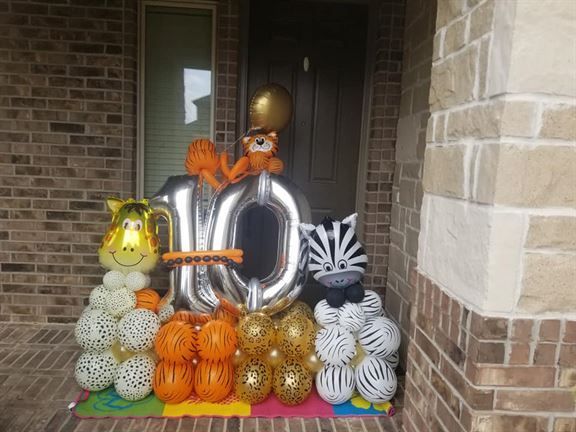 A bunch of balloons are sitting in front of a brick building.