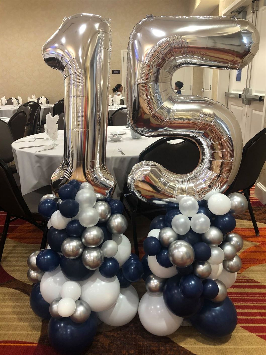 A bunch of balloons with the number 15 on top of them.