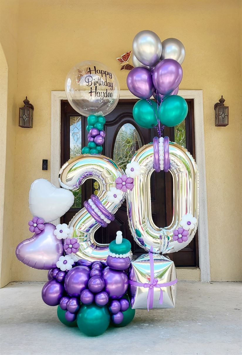 A bunch of balloons are sitting in front of a door.