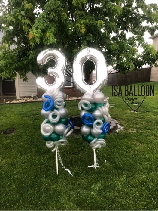 A couple of balloons sitting on top of a lush green field.