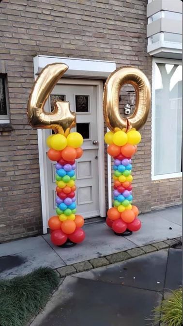 A bunch of balloons are sitting in front of a door.