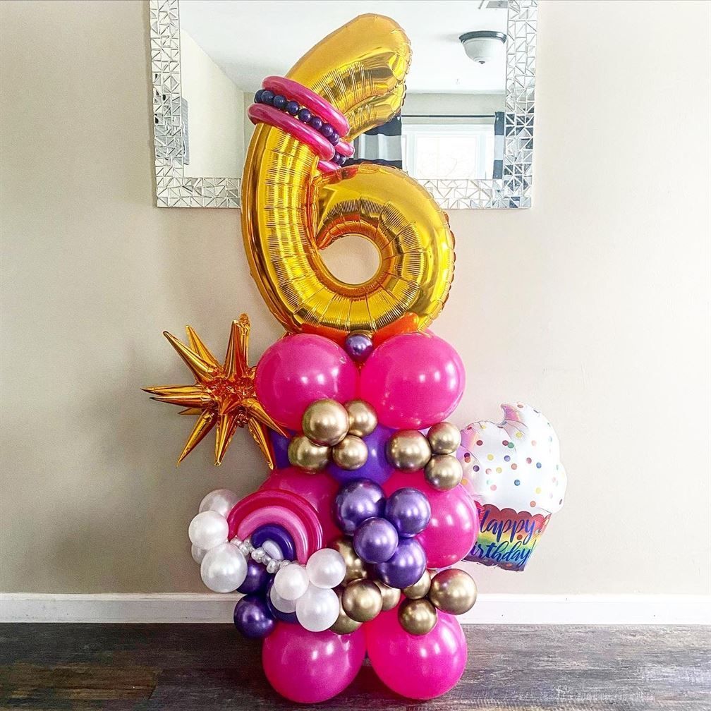 A bunch of balloons are stacked on top of each other in a room.