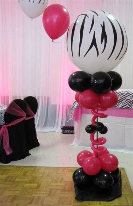 A zebra print balloon is surrounded by red and black balloons