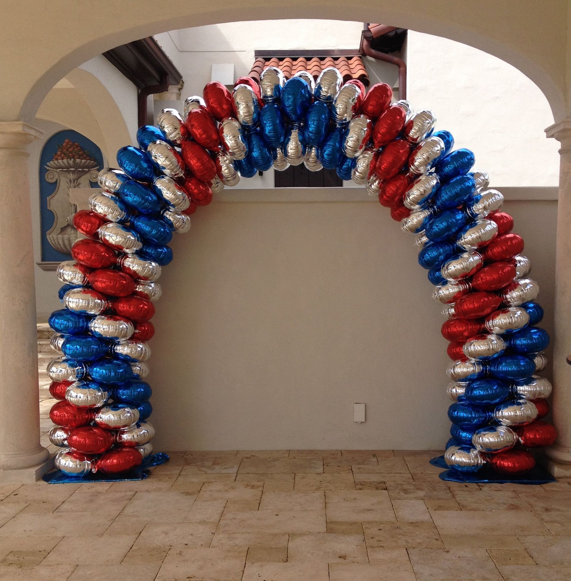 An arch made of red white and blue balloons