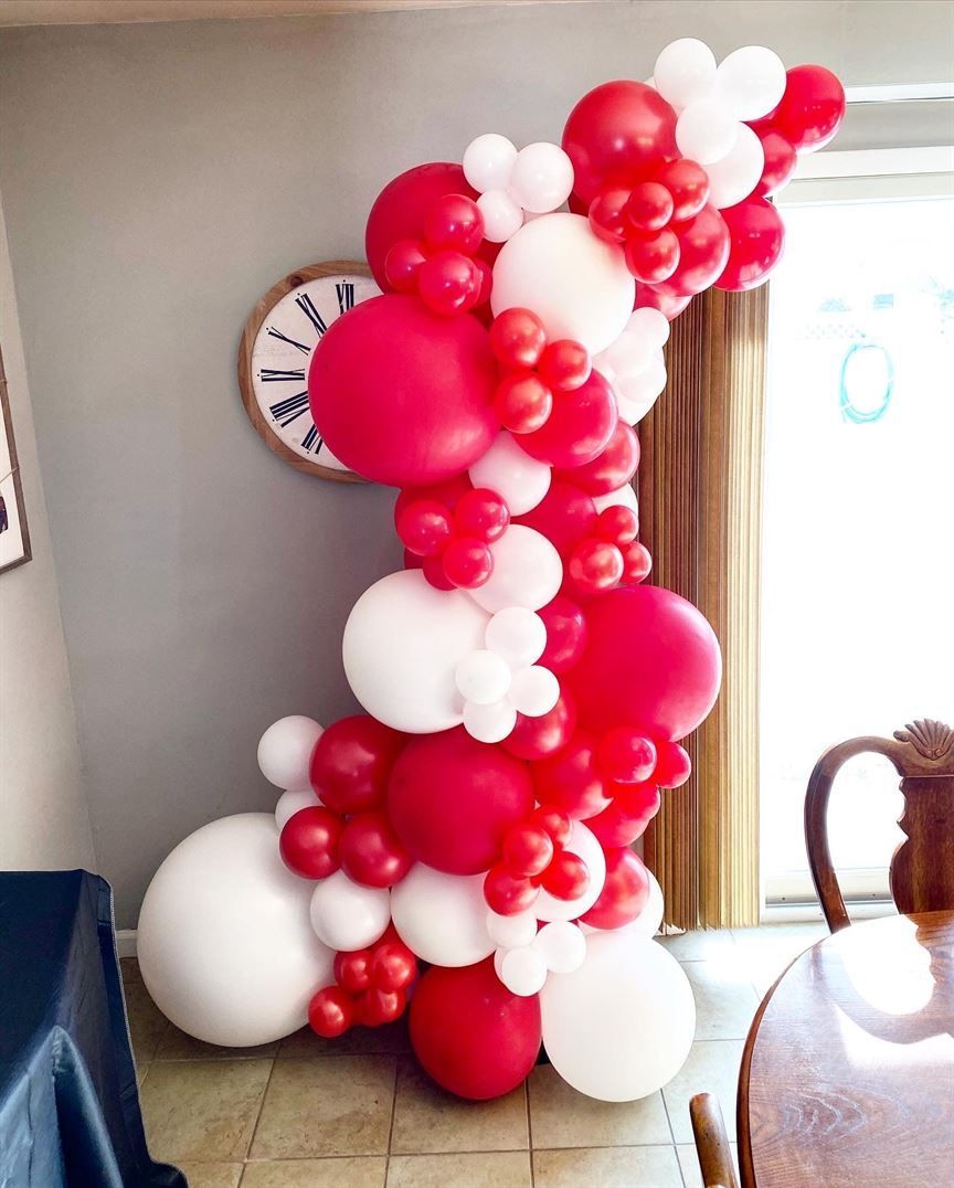 A bunch of red and white balloons in a room