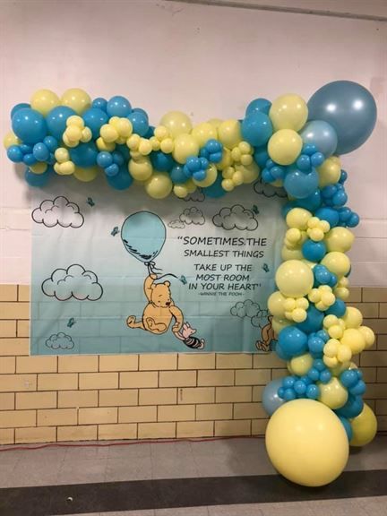 A wall with balloons and a poster that says sometimes the smallest things take up the most room in your heart