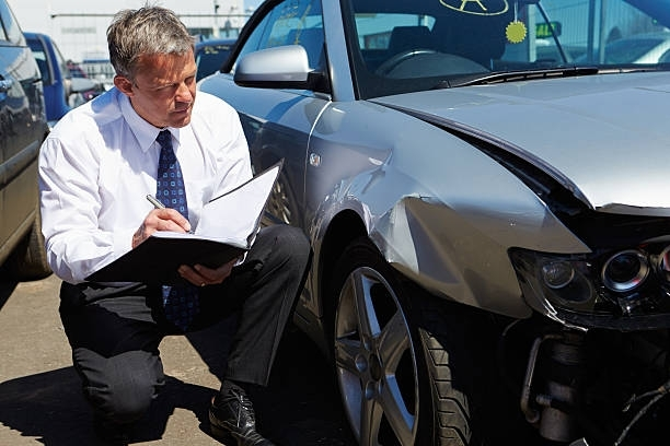 Car accident lawyer from Kmiec Law Offices in Milwaukee, WI, inspecting a car involved in an accident