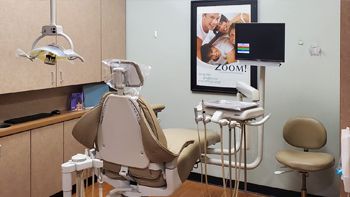 a dental office with a dental chair and a monitor .