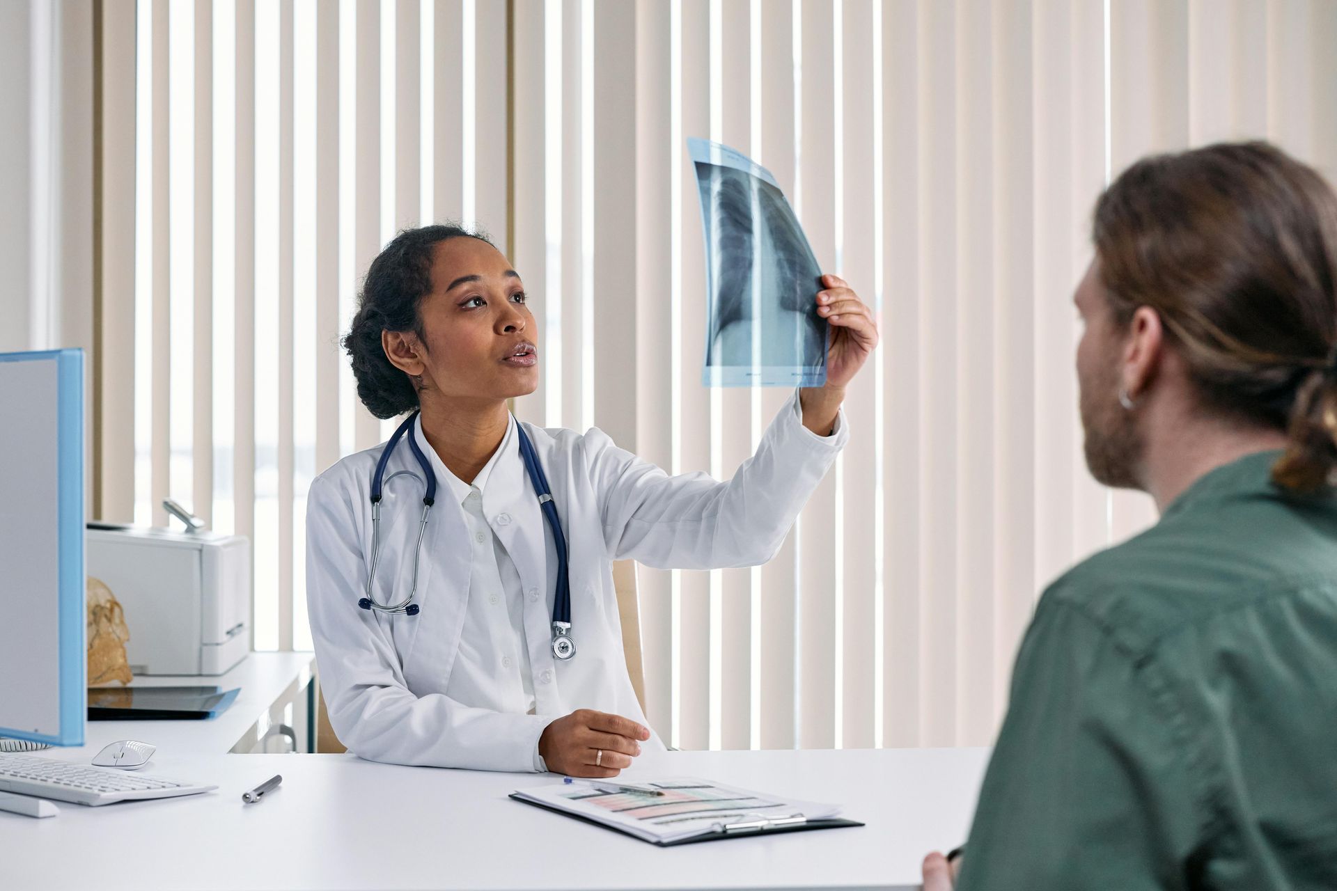 A doctor is looking at an x-ray of a patient 's lungs.
