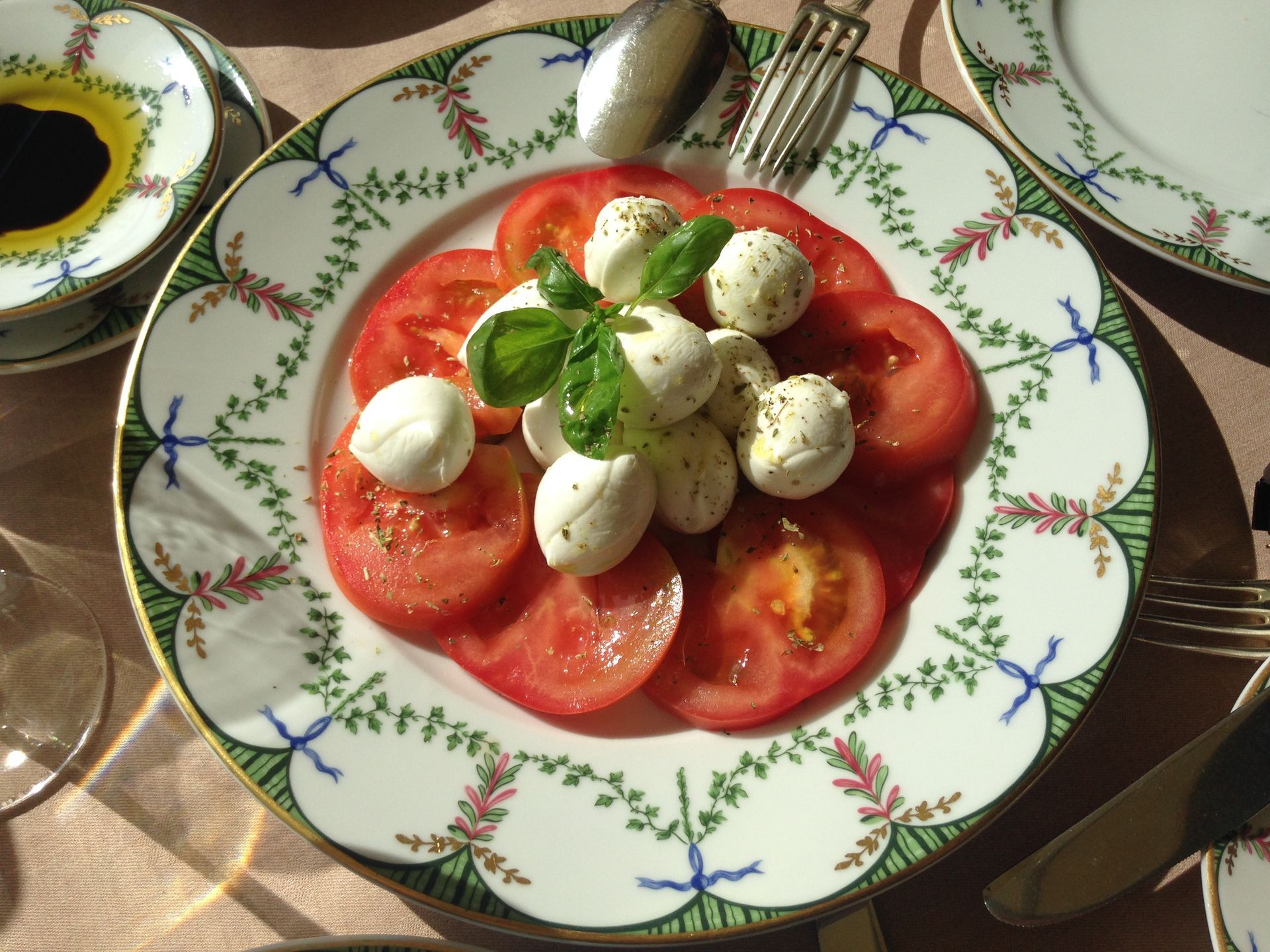 A plate of tomatoes and mozzarella balls on a table