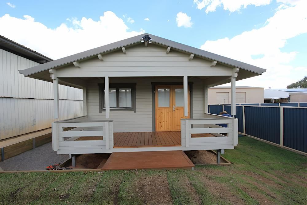 A Small House With a Porch and a Blue Fence — Downright Carpentry in Ryan, QLD