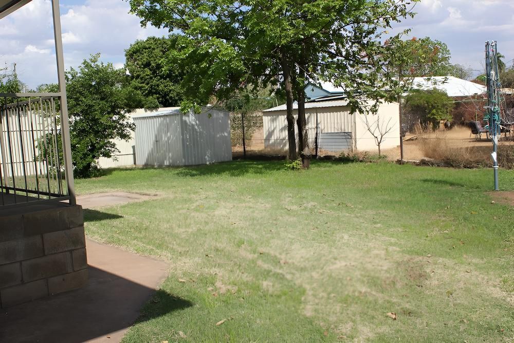 A Lush Green Yard With a White Building in the Background — Downright Carpentry in Ryan, QLD
