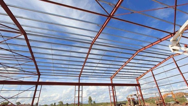 Large Metal Structure is Being Built With a Blue Sky in the Background — Downright Carpentry in Ryan, QLD