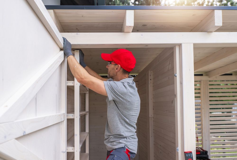 Man in a Red Hat is Working on a Wooden Structure — Downright Carpentry in Ryan, QLD