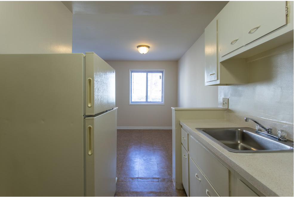 Kitchen with white cabinets and view into dining area