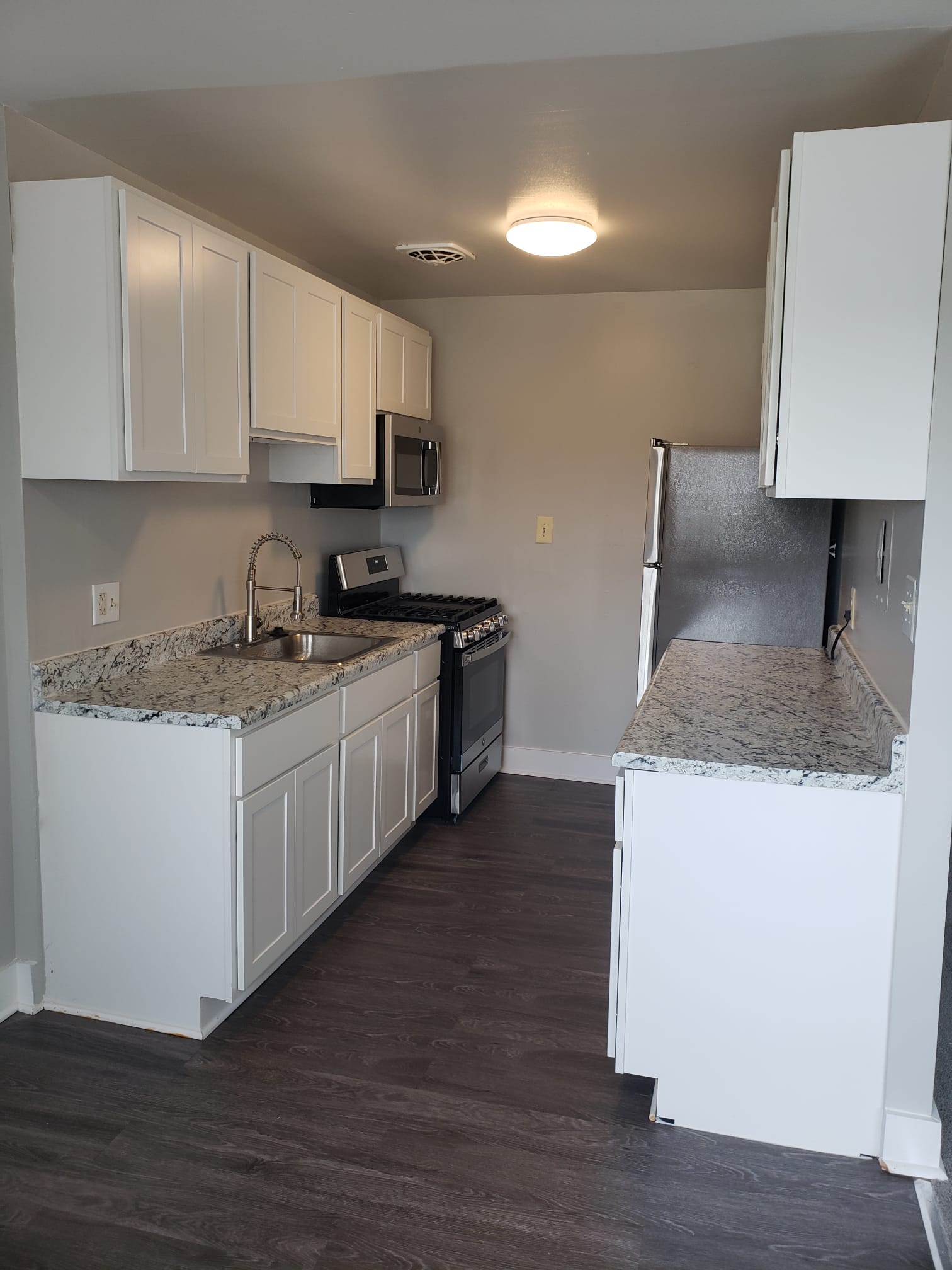 Upgraded kitchen with granite countertops and grey flooring