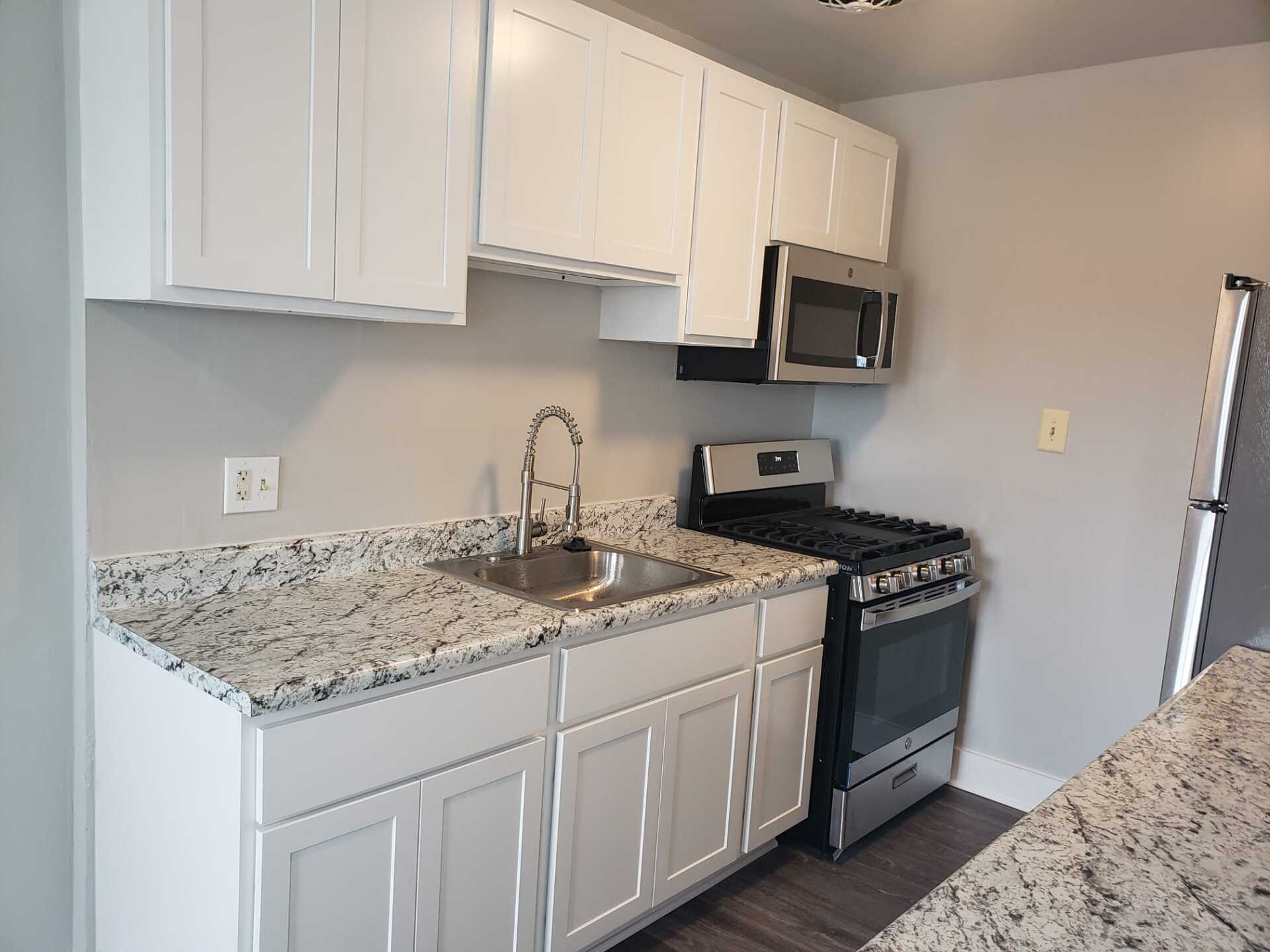 Upgraded kitchen with granite countertops and grey flooring