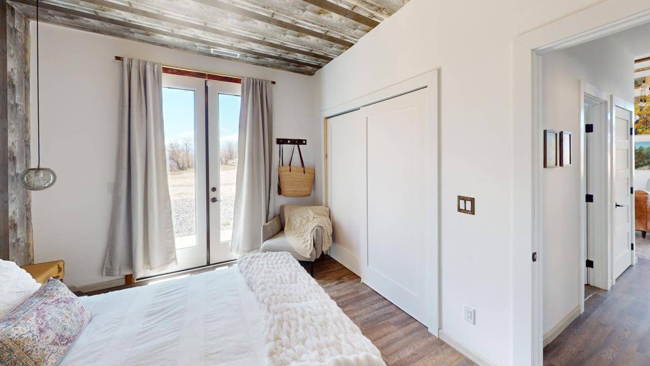 A bedroom with a bed , chair , and closet. Maven Construction, Montrose, CO