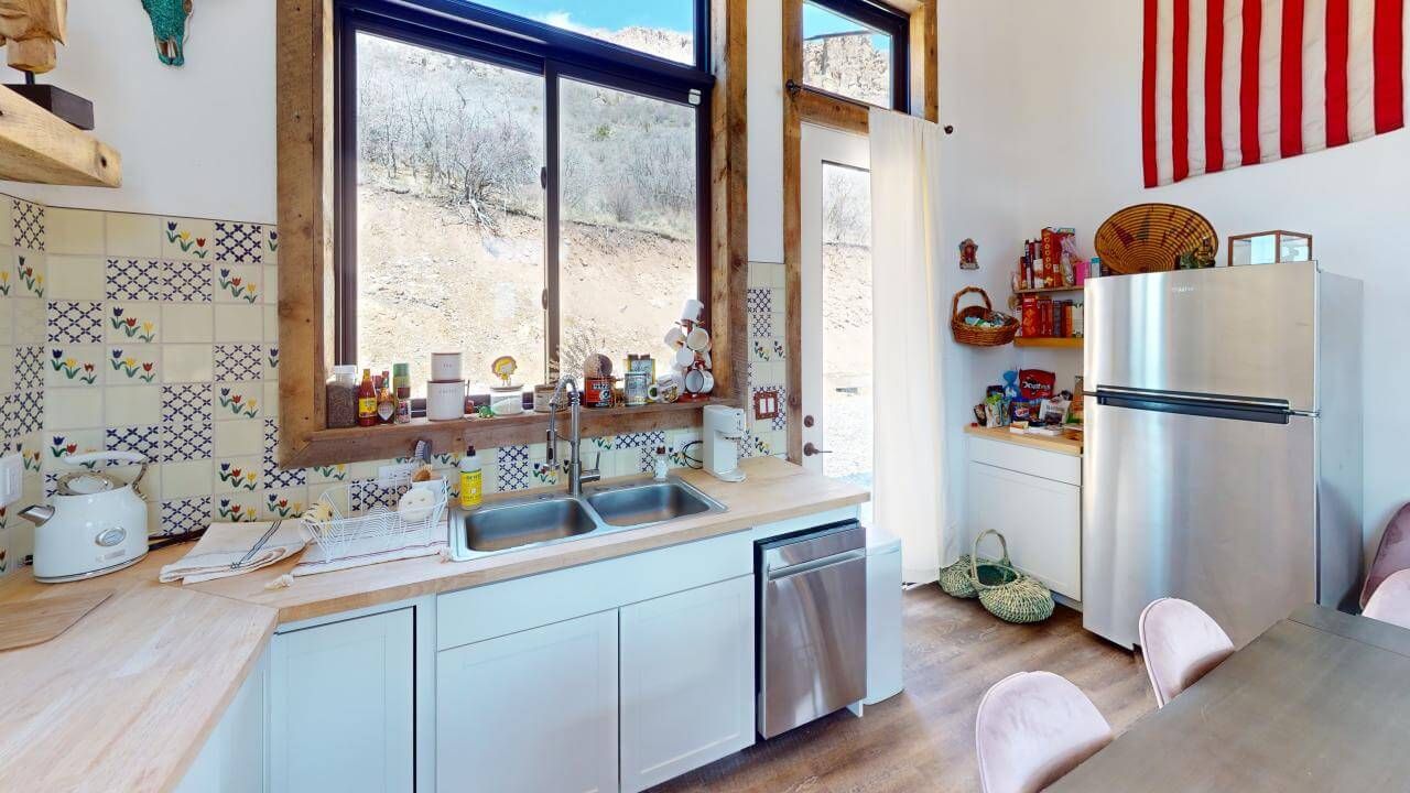 A kitchen with a sink , refrigerator , dishwasher , and american flag on the wall. Maven Construction, Montrose, CO
