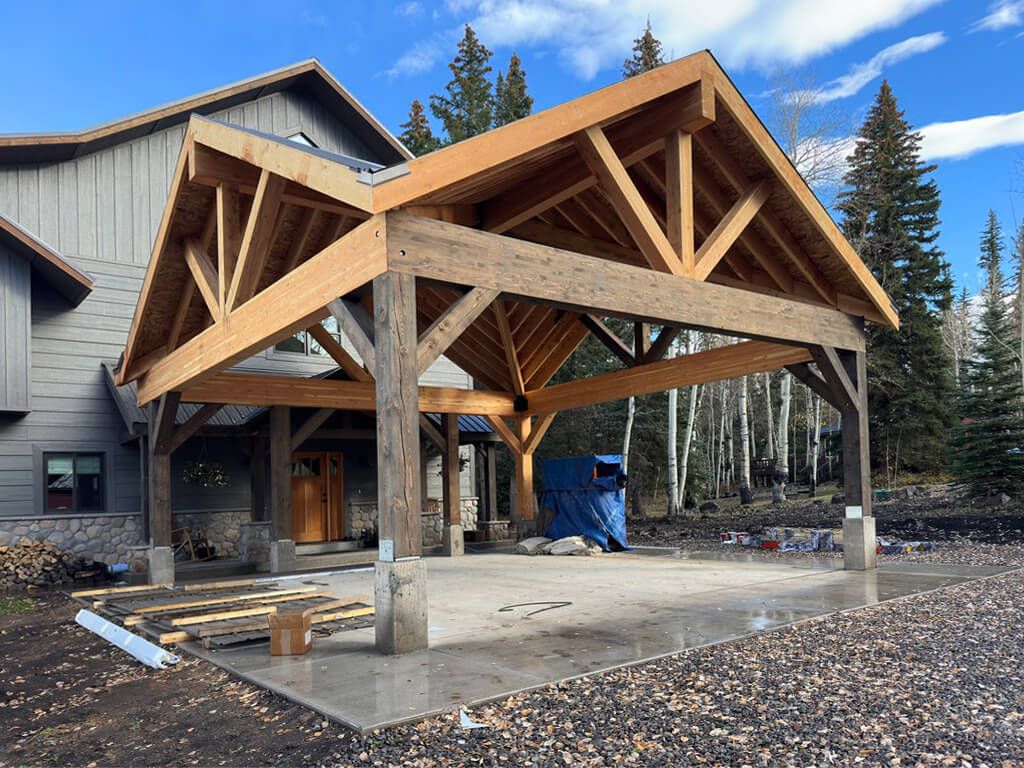 A large wooden structure is being built in front of a house. Maven Construction, Montrose, CO