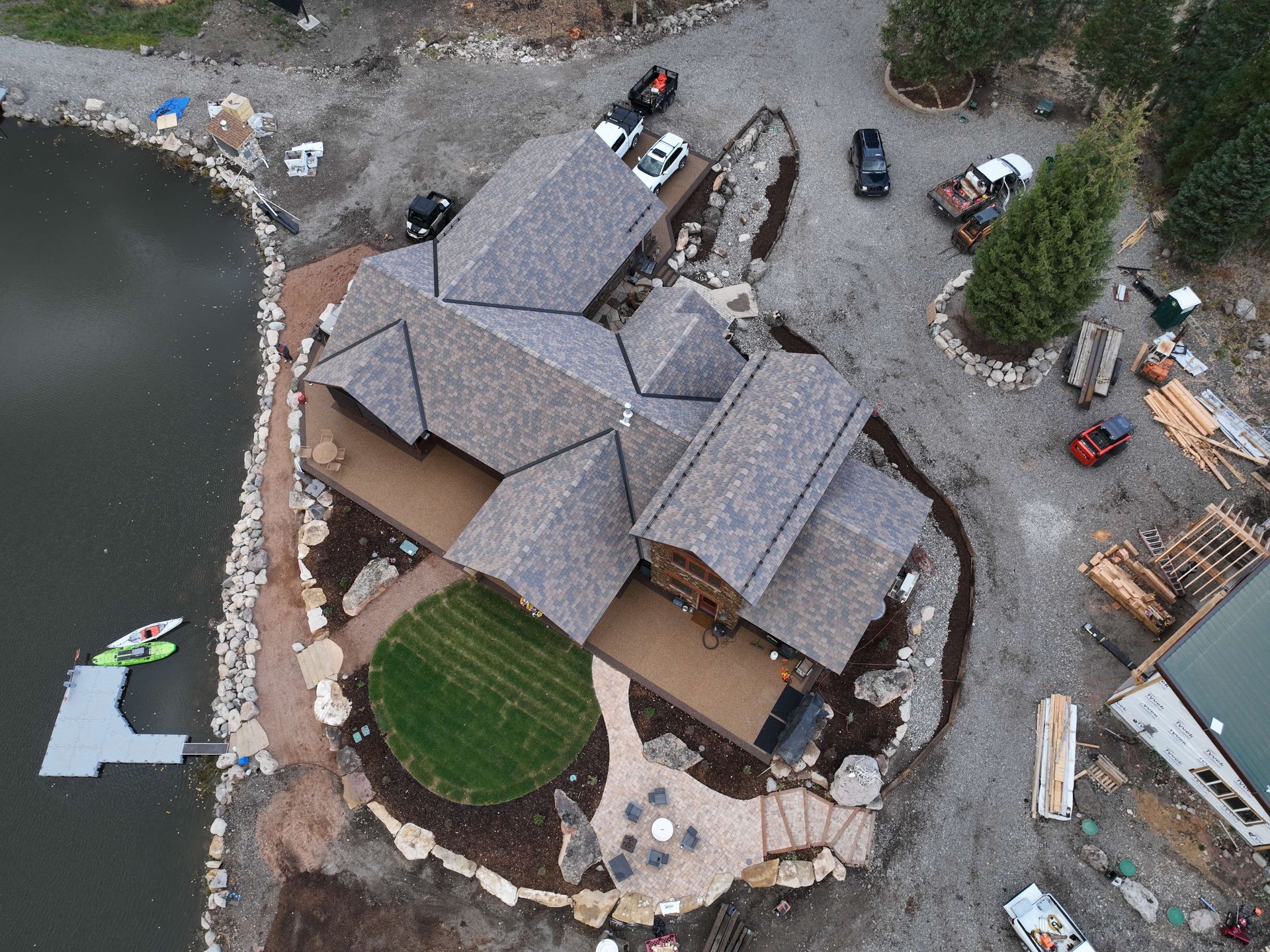 An aerial view of a house under construction next to a lake. Maven Construction, Montrose, CO