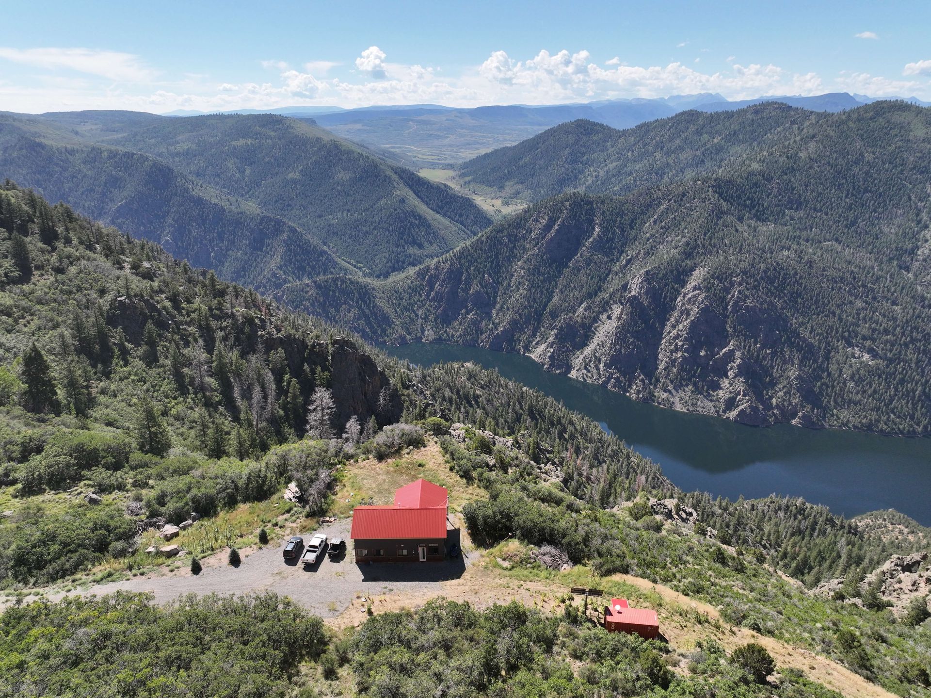 An aerial view of a lake surrounded by mountains and trees Maven Construction, Montrose, CO
