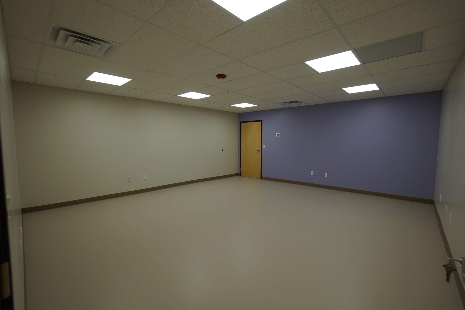 An empty room with purple walls and a door Maven Construction, Montrose, CO