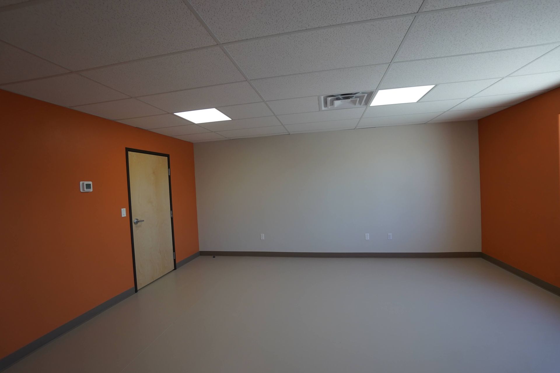 An empty room with orange walls and a door Maven Construction, Montrose, CO