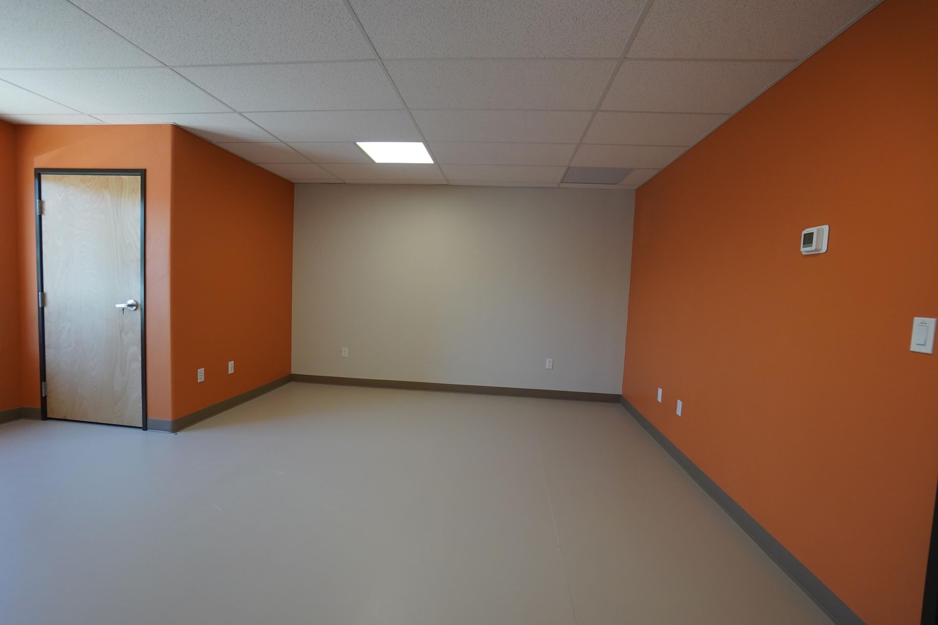 An empty room with orange walls and a door Maven Construction, Montrose, CO