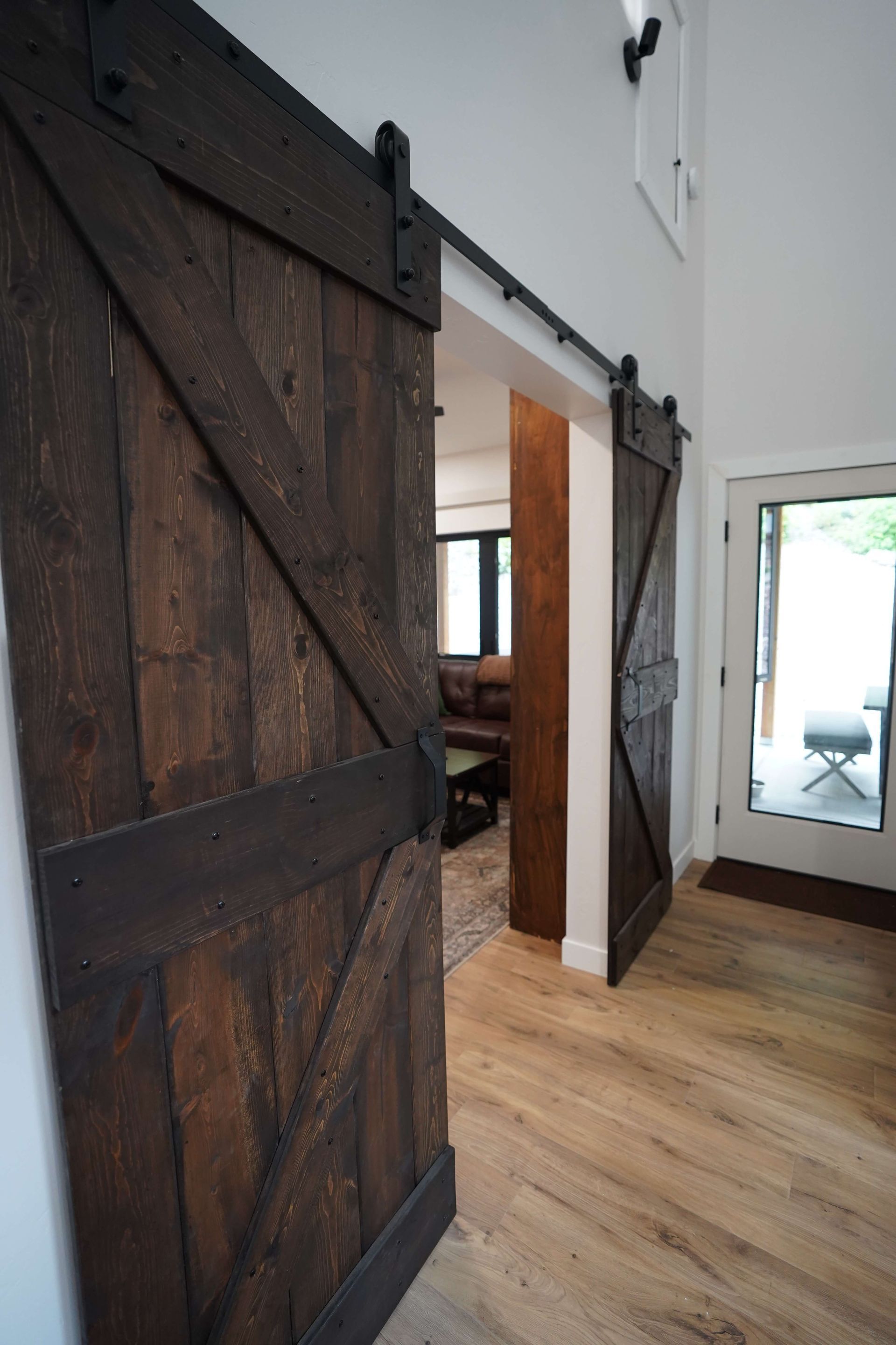 A hallway with sliding barn doors leading to a living room.