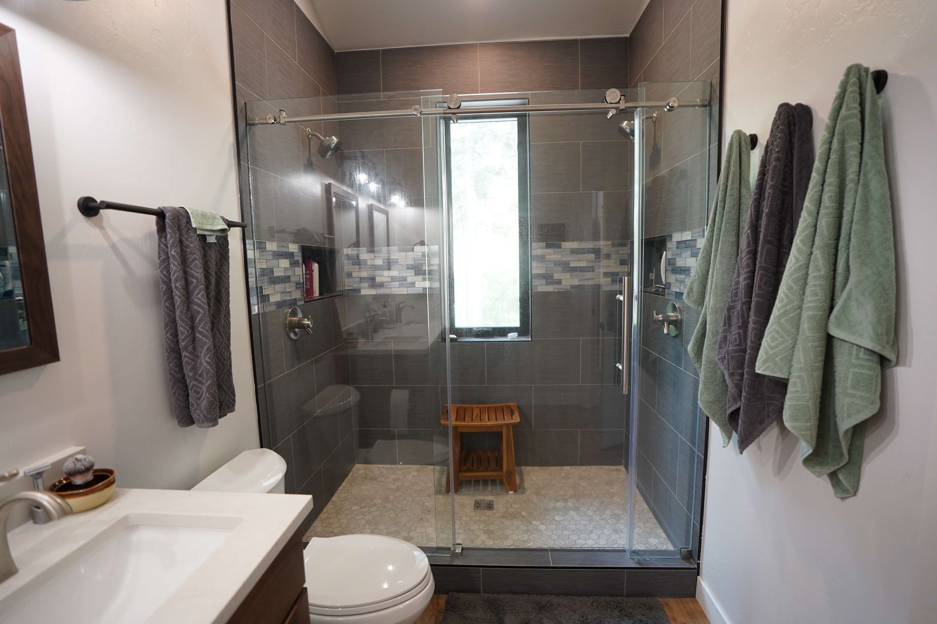 A bathroom with a toilet , sink , and walk in shower.