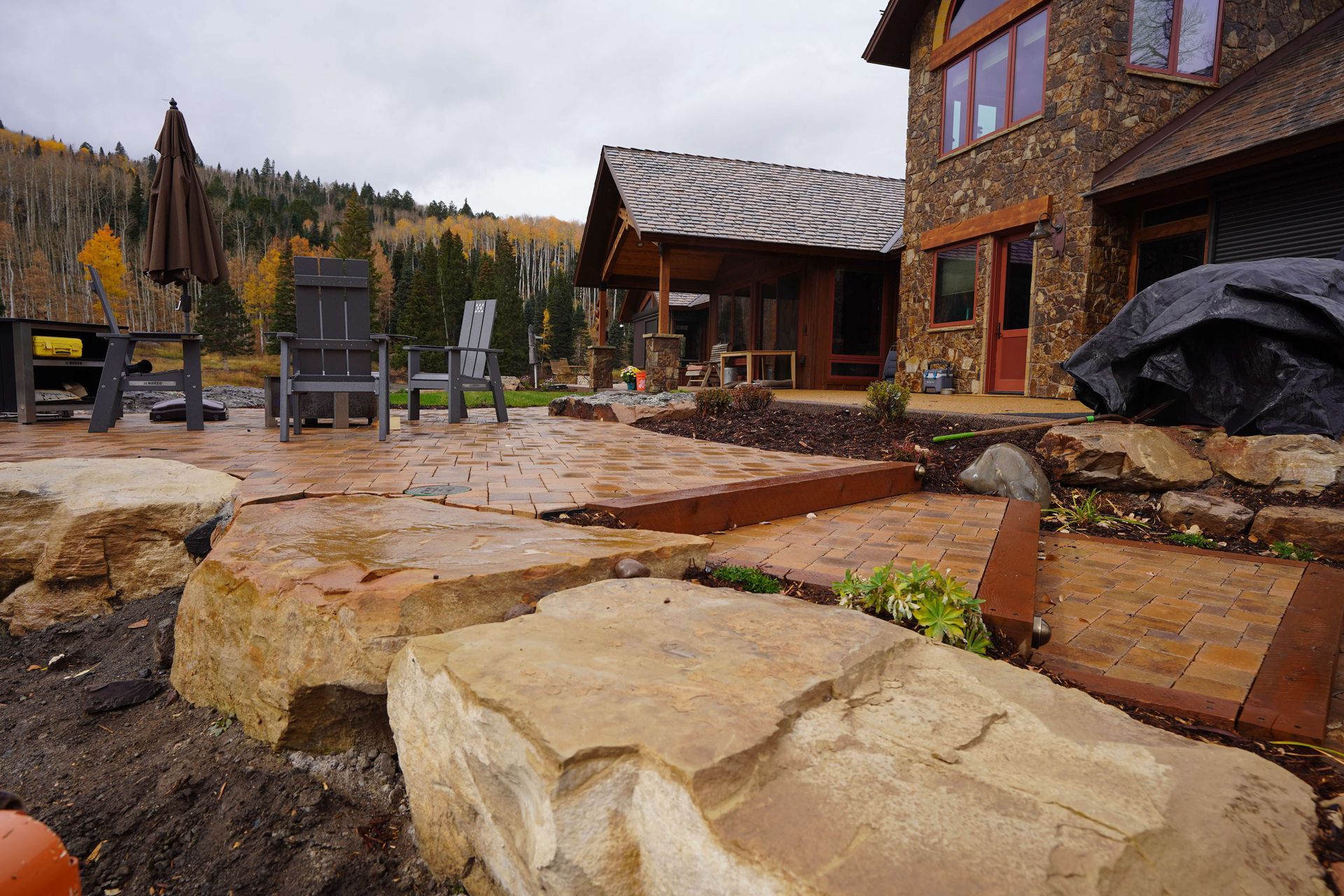 A large stone house with a patio and chairs in front of it. Maven Construction, Montrose, CO