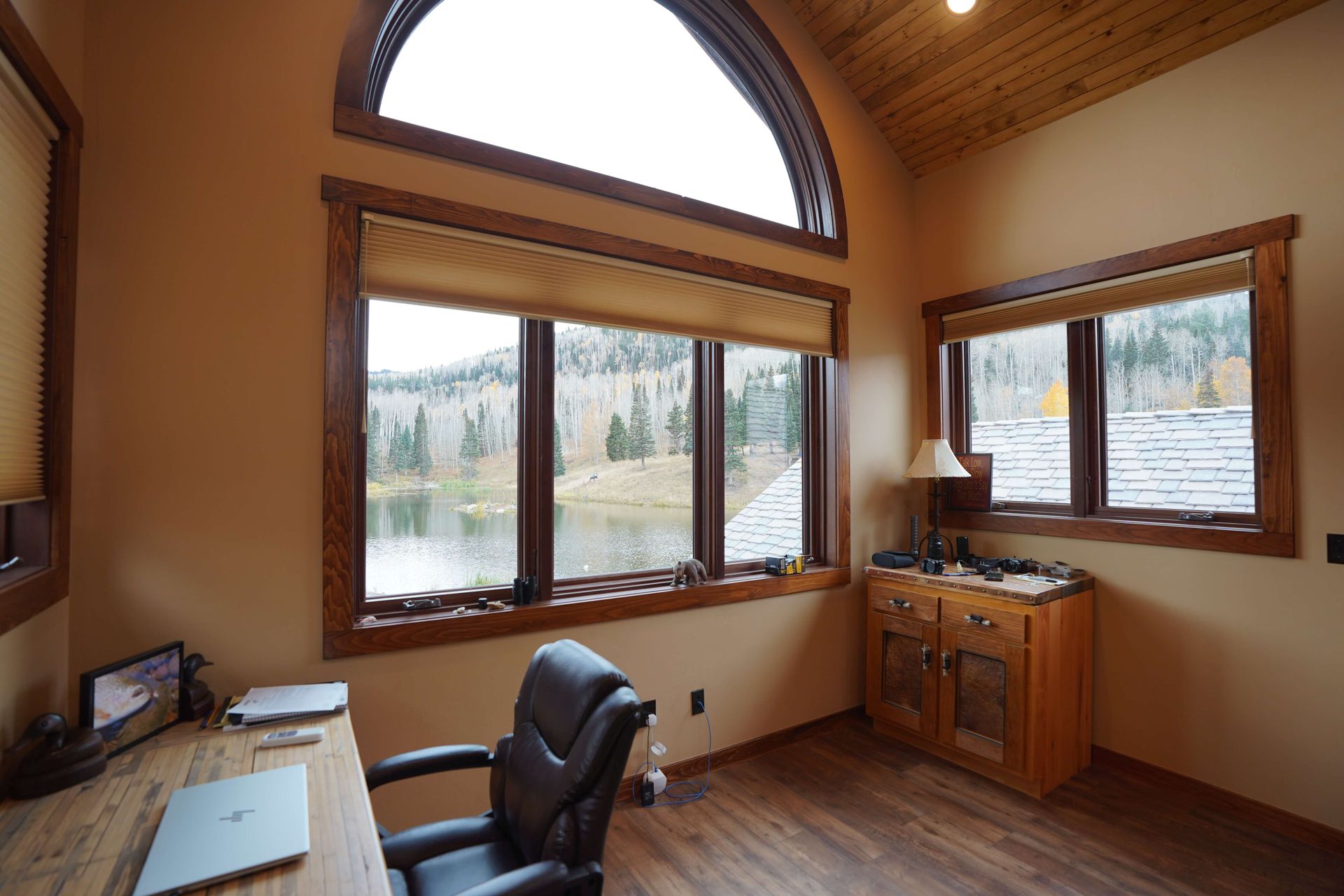 A room with a desk and chair and a large window with a view of a lake. Maven Construction, Montrose, CO