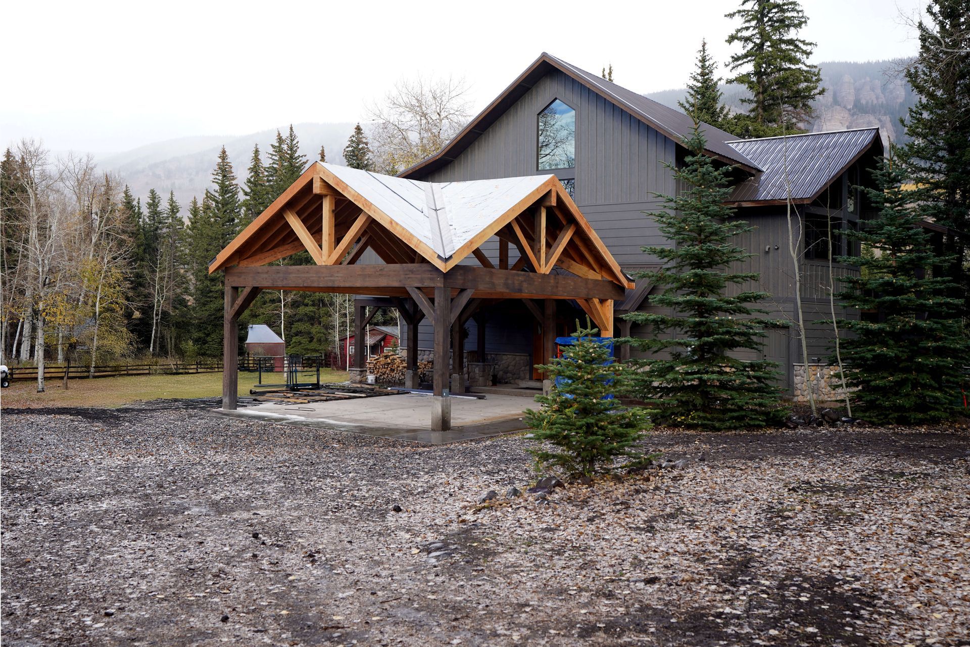 A large house with a carport in front of it surrounded by trees. Maven Construction, Montrose, CO