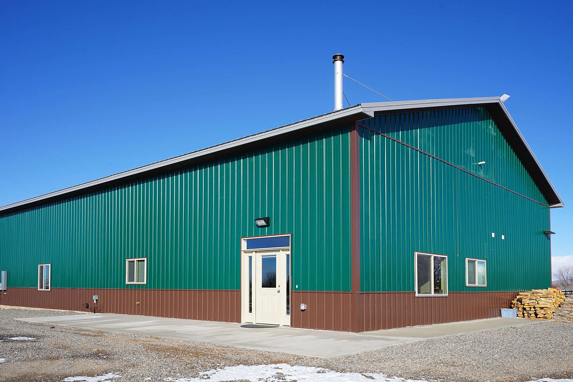 A large green and brown building with a door and windows. Maven Construction, Montrose, CO