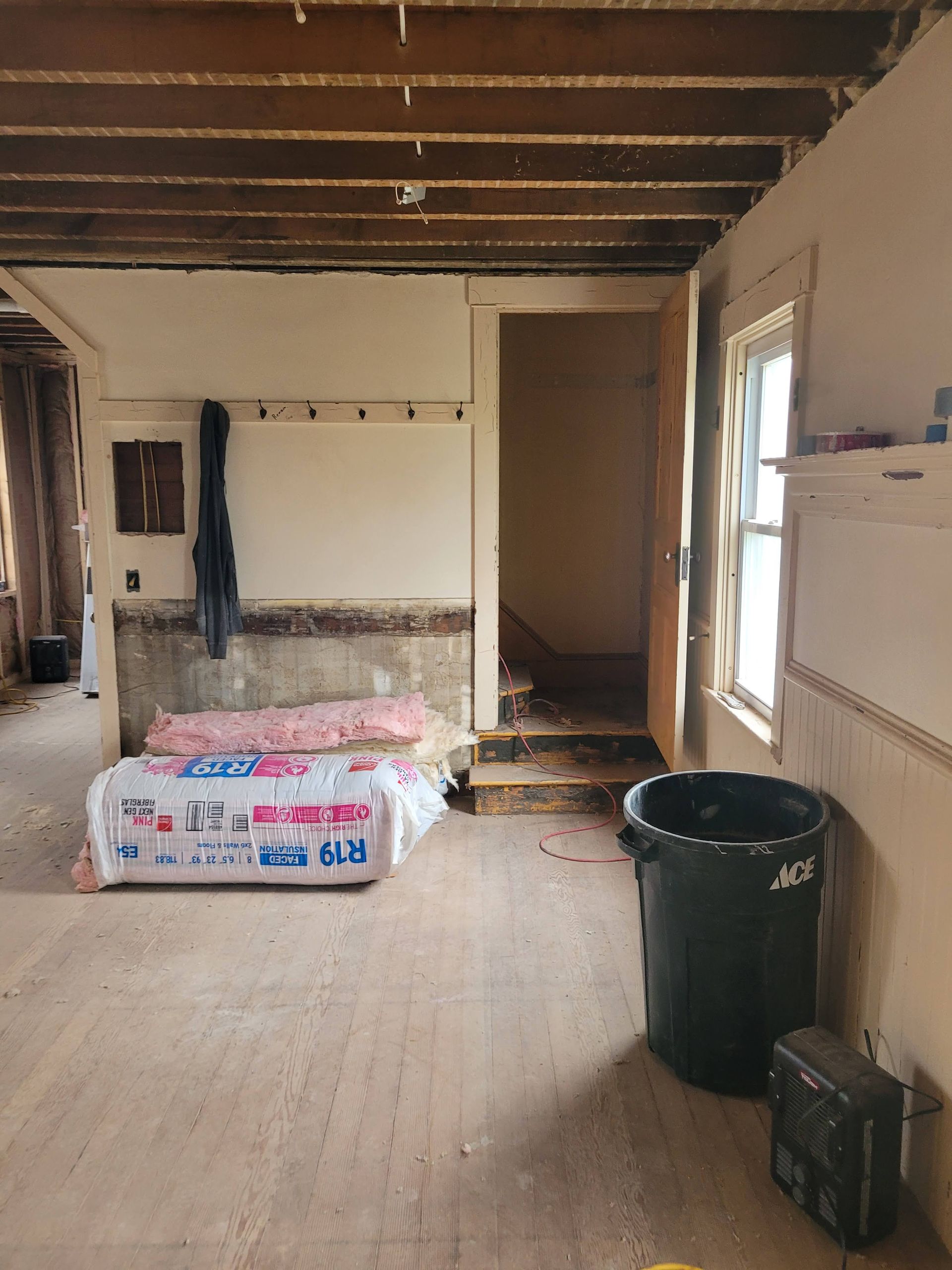 Two men are sitting at a table looking at a blueprint.