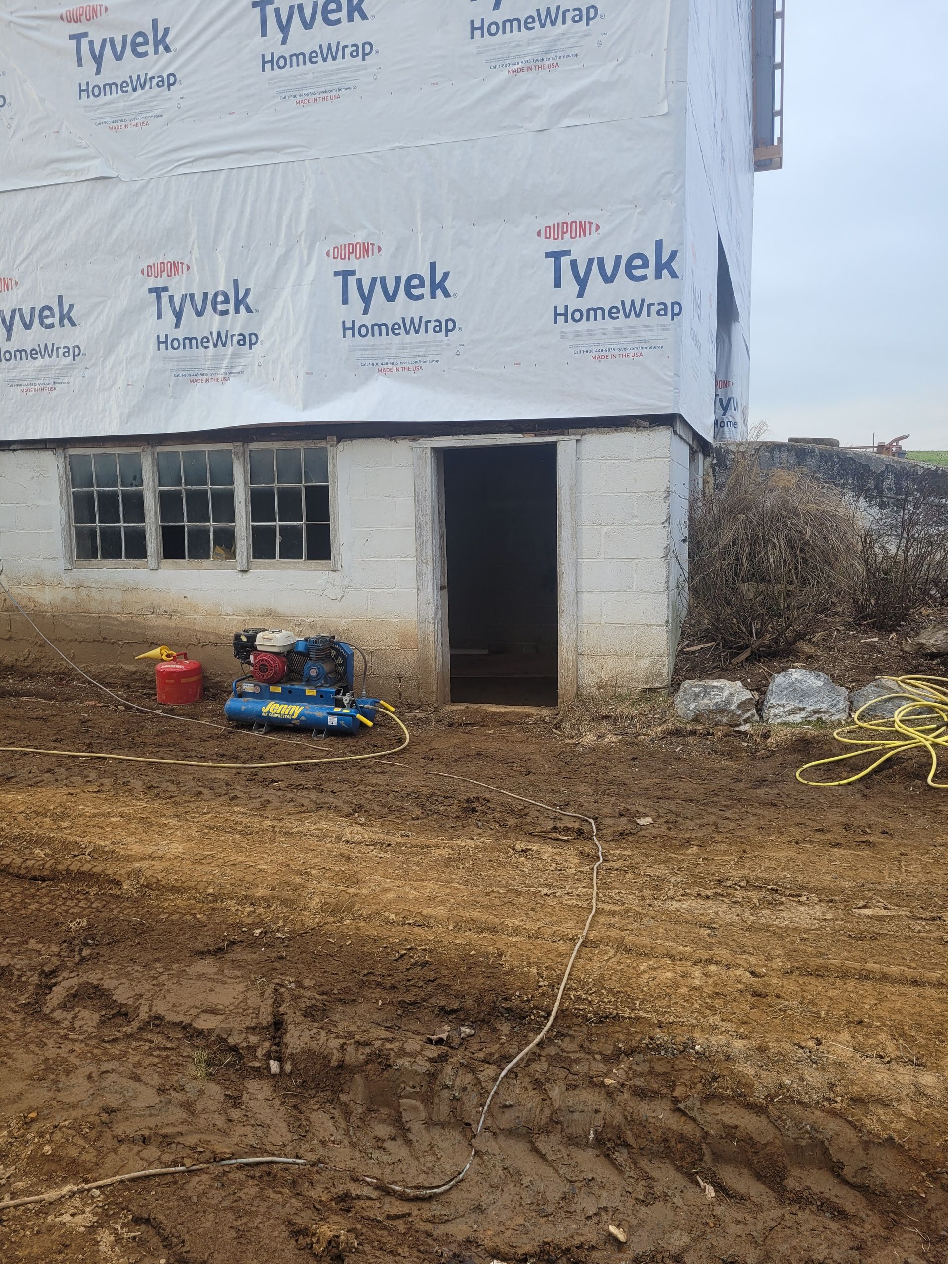 A wheelbarrow is sitting in the middle of an empty building under construction.