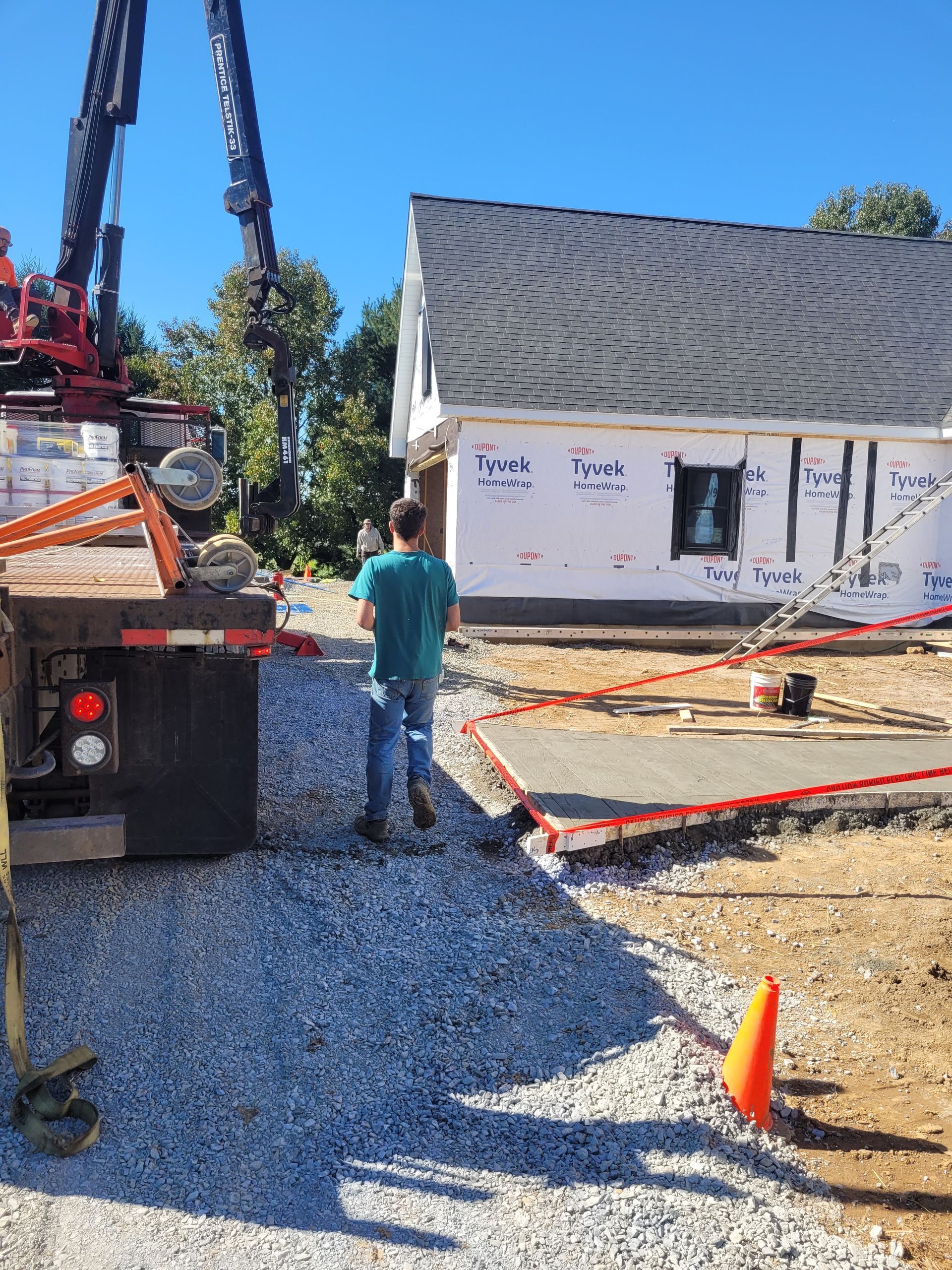 Two construction workers are walking through a building under construction.