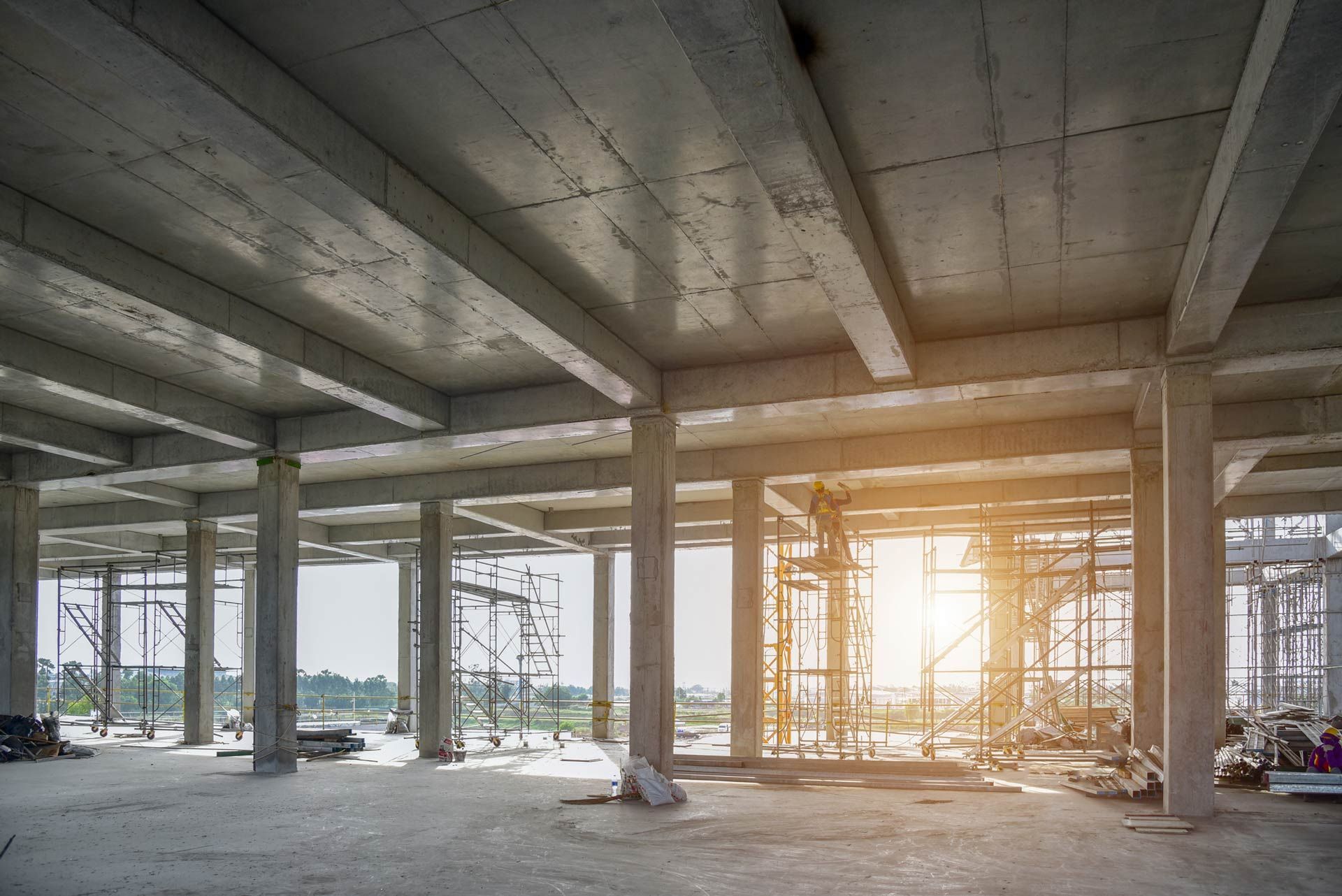 The sun is shining through the windows of a building under construction.