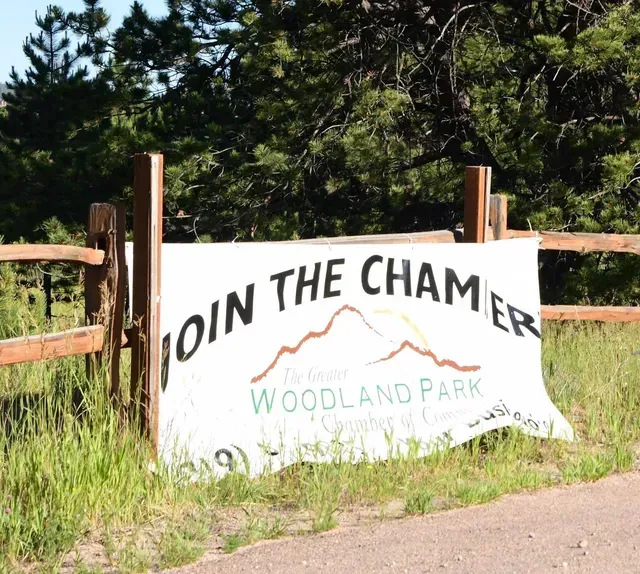 Banner on a wooden fence reads: