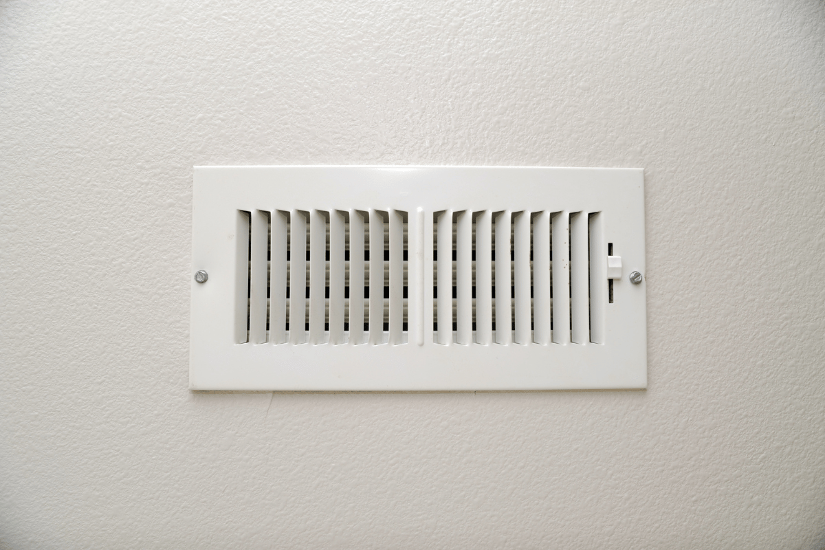 White rectangular air vent on a white wall.