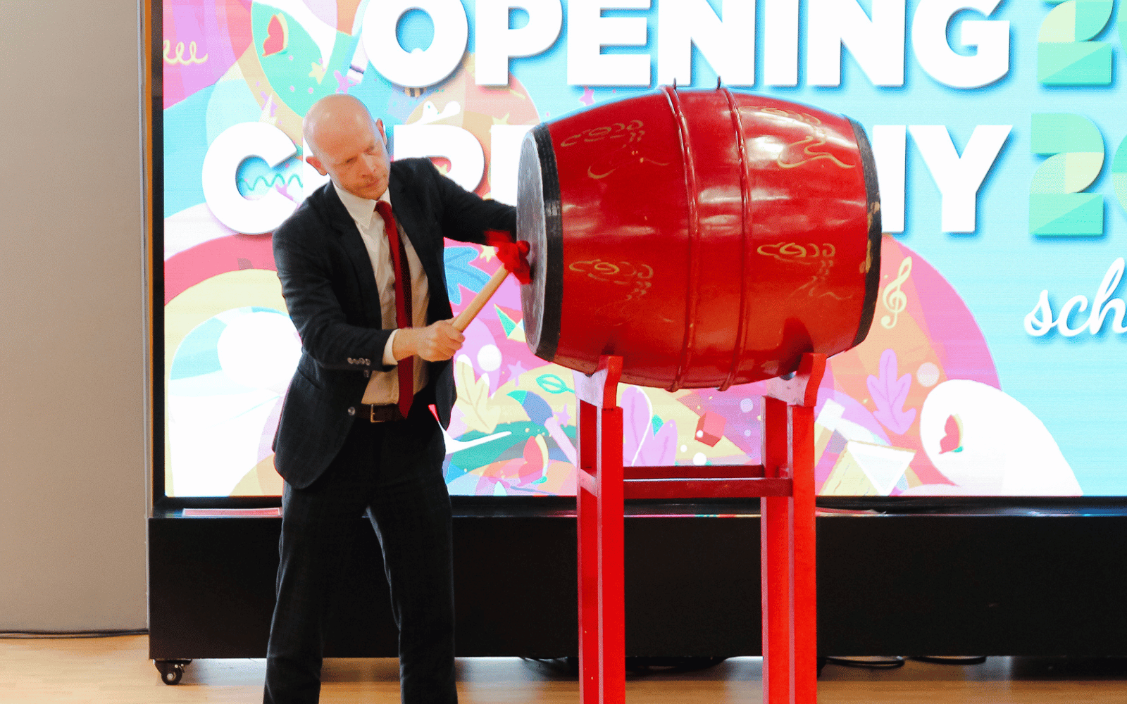 bilingual school leader banging drum
