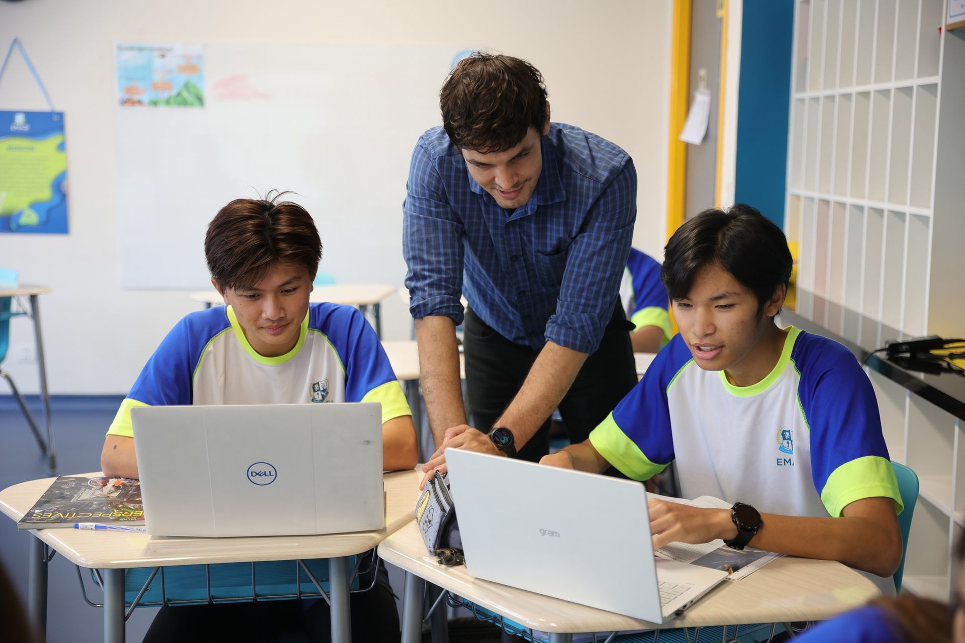 a teacher teaching students with laptops