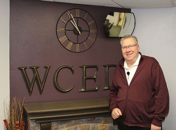 Aaron J. Budweg stand with WCED sign