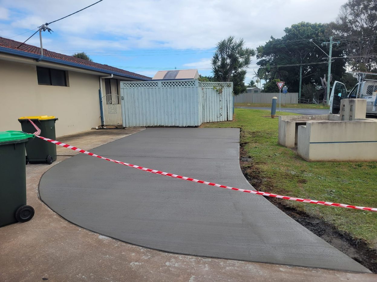 Concrete Driveway With Red/white Stripe Barricade Tape — Kempsey Concrete Contractors In Kempsey, NSW