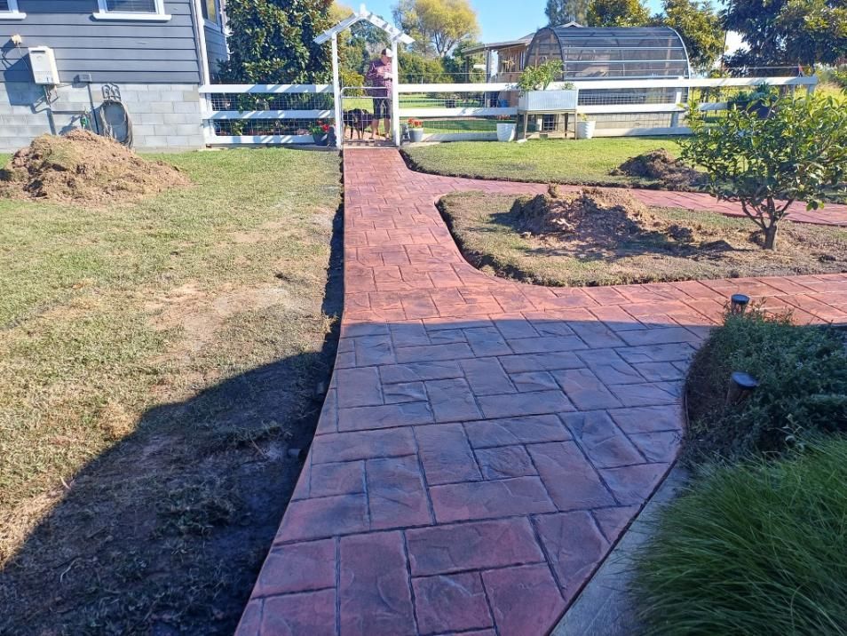 Brick-patterned Pathway Through a Yard Leads to a White Gate — Kempsey Concrete Contractors In South West Rocks, NSW