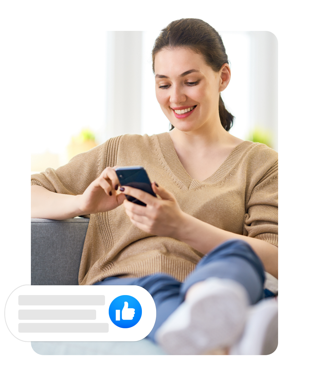 A woman is sitting on a couch looking at her phone.