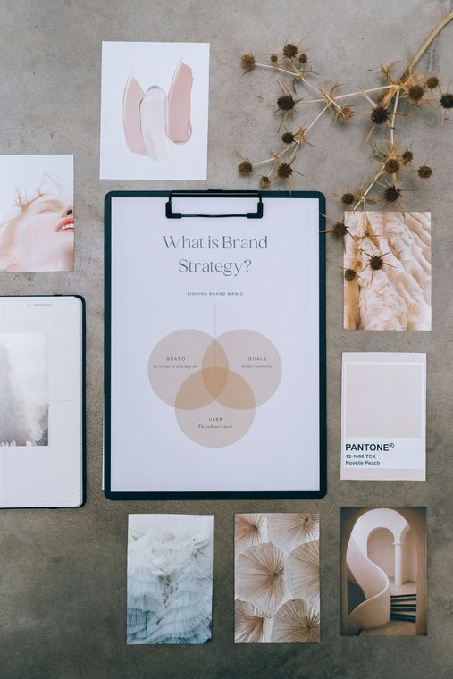 A clipboard with a piece of paper on it is surrounded by papers and flowers.