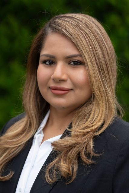 A woman in a suit and white shirt is posing for a picture.